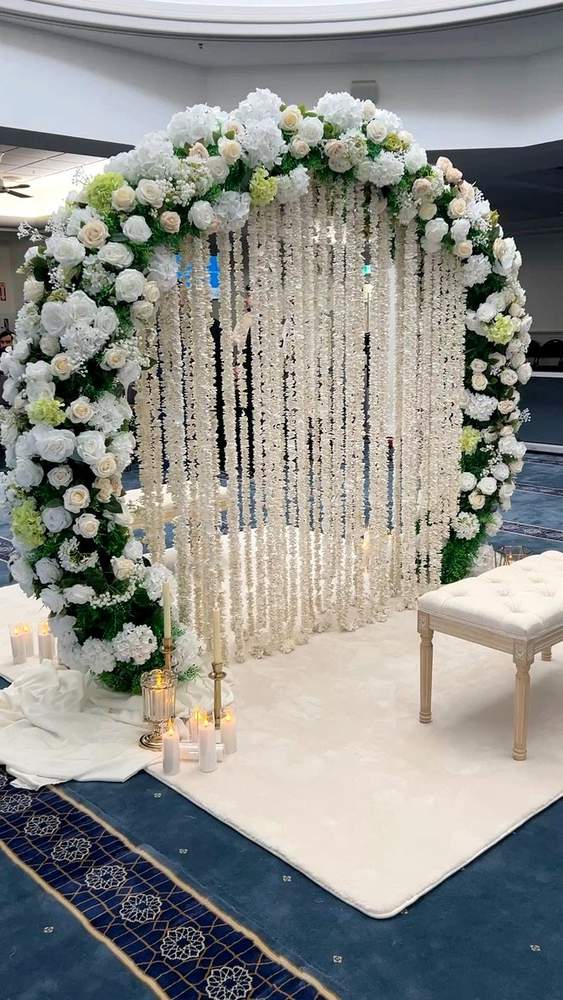 Close view of pearl strands, candles and white floral details on a Nikkah divider