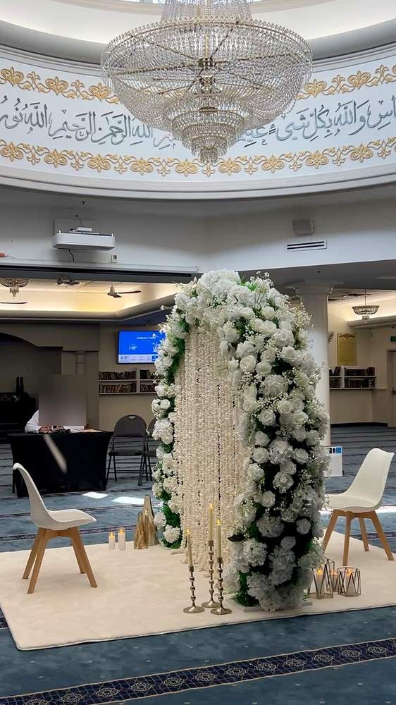 White floral Nikkah divider beneath a mosque chandelier